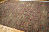 Geometric gul motifs in wine red and copper on antique Turkmen carpet, with prominent wear.