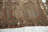 Antique Turkmen carpet's geometric gul motifs, wine red, navy, terra cotta colors, showing holes.