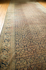 Intricate Herati motif on an antique Khorassan rug with distressed navy and beige hues.