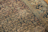 Close-up of the antique Khorassan rug's distressed pile, revealing wear to knot heads and foundation.