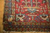 Heriz runner corner detail showing wear, tattered fringe, and a hole.
