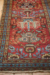 Cherry red Heriz runner pile detail with sky blue blossoms, green vinery, and even wear.