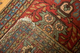Heriz rug corner detail, showing cherry red pile with floral motifs and hand-knotted backing.