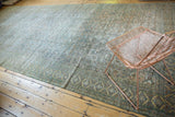 Distressed antique Khorassan carpet showing faded Herati motif and subtle ocean green hues.