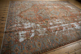 Low angle view across a distressed antique Karaja carpet showing its worn texture and copper tones.