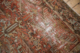 Localized wear on distressed Mehrivan rug, showing faded brick red and ivory serrated motifs.