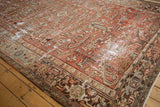 Distressed vintage Mehrivan carpet showcasing worn pile, faded brick red, and serrated leaf patterns.
