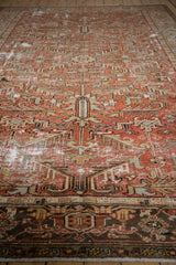 Faded brick red serrated leaf pattern and dark charcoal border on a distressed vintage Mehrivan carpet.