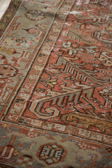 Textural view of vintage distressed Mehrivan carpet; faded brick red, silver serrated leaf motifs, worn pile.