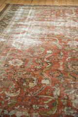 Distressed vintage Mahal carpet pile showing exposed foundation and terra cotta floral pattern.