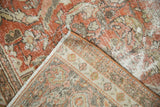 Distressed Mahal carpet corner, showing terra cotta pile, exposed beige foundation, and side binding.
