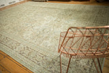 Muted ivory, pale blue, and green floral design on a distressed vintage Mahal carpet.