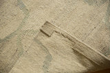 Close-up of the tightly hand woven Kilim carpet texture in ivory and pale slate grey.