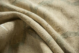Textured folds of a hand woven kilim rug in ivory and pale slate grey.