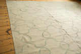 Angled view of ivory Kilim carpet featuring pale slate grey Moroccan tile vines.