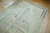 Distressed Oushak runner with even wear and a geometric charcoal border pattern.