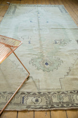 Distressed Oushak rug lower border, showing charcoal serrated leaf motifs on textured pile.