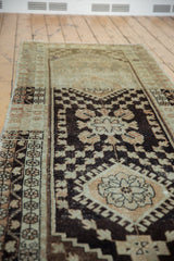 Distressed Oushak runner with dark chocolate brown and pale terra cotta blossomed floral pattern.