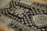 Vintage distressed Oushak runner's dark chocolate field with pale terra cotta blossomed design.