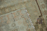 Folded corner of vintage Oushak runner showing reverse, fringe, and patched wear.
