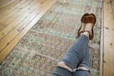 Distressed vintage Malayer runner section, highlighting terra cotta boteh and geometric border.
