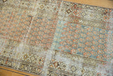 Distressed vintage Malayer runner's geometric border and time-softened terra cotta, ocean green boteh motifs.