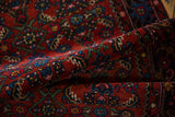 Plush wool pile showcasing intricate Herati motif in deep ruby and sapphire tones.
