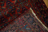 Vintage Engelas runner corner, revealing hand-knotted Herati motif, ruby red pile, and cream fringe.