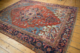 Vintage Heriz carpet's bold medallion, serrated leaves in madder root red and sky blue.