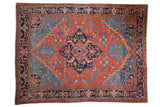 Antique Heriz carpet featuring a bold madder red field and navy medallion with germinating plant motifs.