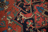 Madder root red, navy, and mallard green geometric motifs on antique Heriz rug with even wear.