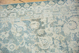 Distressed vintage Agra cotton rug detail: faded dusty blue floral buds, ivory low pile.