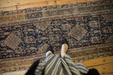 Antique Malayer runner's detailed henna plant and paisley motifs with visible wear to knot heads.