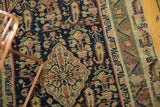 Intricate border and henna plant motifs on a navy field, antique Malayer rug.