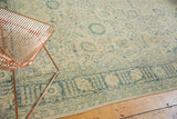 Distressed vintage Tabriz rug corner, faded blue Safavid vinery on ivory with foundation showing.