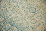 Distressed vintage Tabriz corner: faded sky blue floral vinery and border detail.