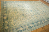 Distressed Tabriz carpet corner, denim blue Safavid motifs, and faint foundation showing.