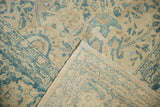 Distressed vintage Tabriz carpet's faded blue palmettes and hand-knotted back.