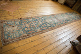 Distressed Malayer runner with decorative worn pile, dusty blue, ivory, and sand motifs.