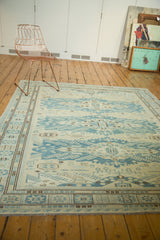 Angled view of new Soumac square carpet, ivory field with blue and brown patterns.