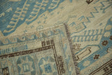 Hand-woven Soumac carpet corner revealing tight flatweave, fringe, and slate blue, ivory patterns.