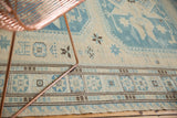 Hand-woven Soumac rug with fine geometric border and ivory, slate blue starburst motifs.