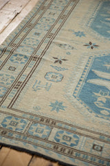 Fine hand woven Soumac carpet detail with chocolate brown geometric border and slate blue starbursts.