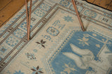 Ivory geometric starbursts and blue medallion detail on a hand woven Soumac style rug.