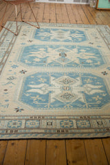 Soumac carpet's geometric border in ivory, slate blue, and chocolate brown, with fringe.