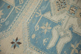 Fine woven Soumac carpet featuring geometric starburst and checkered floral motifs, slate blue, ivory.
