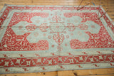Distressed Oushak rug corner detail with faded cherry red and powder blue vinery motif.