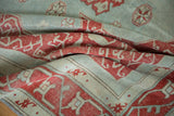 Faded cherry red vinery pattern on distressed powder blue vintage Oushak rug pile.