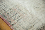 Worn texture and exposed foundation of a distressed Oushak rug, showing pale rose patterns.