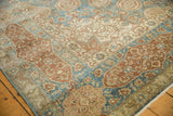 Distressed Tabriz carpet corner detail showing sapphire blue, dusty wine red, ivory, and even wear.